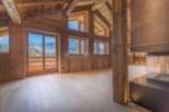 This stunning chalet boasts a spacious open-plan living area with floor-to-ceiling windows offering breathtaking mountain views.