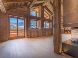 This stunning chalet boasts a spacious open-plan living area with floor-to-ceiling windows offering breathtaking mountain views.