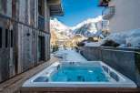 Escape to a luxurious mountain retreat with a private hot tub overlooking stunning alpine views.