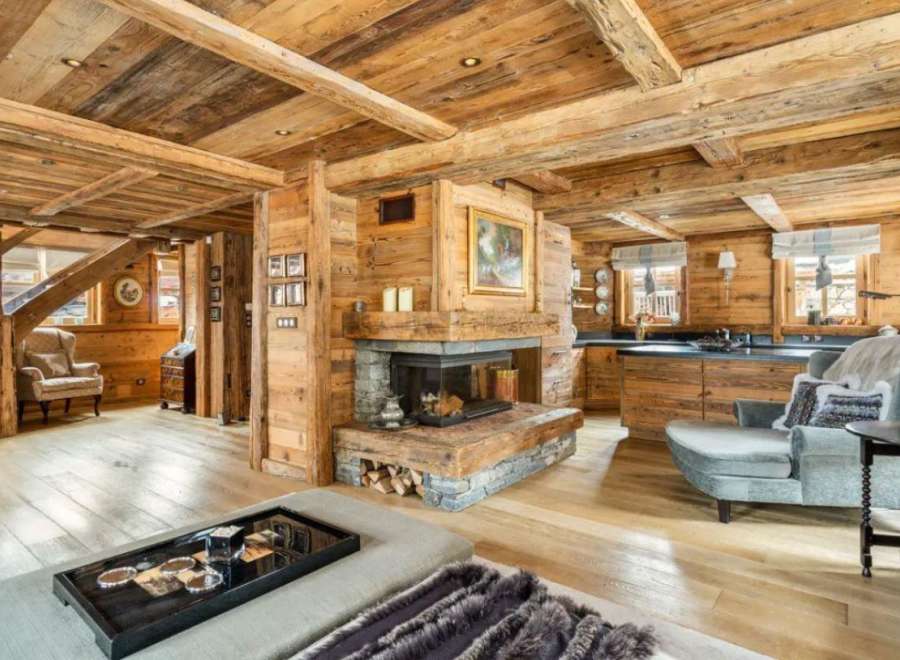 This stunning chalet boasts a magnificent wooden interior, complete with exposed beams and a cozy fireplace.