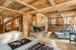 This stunning chalet boasts a magnificent wooden interior, complete with exposed beams and a cozy fireplace.