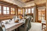 This stunning chalet boasts a spacious dining area with large windows offering breathtaking mountain views.