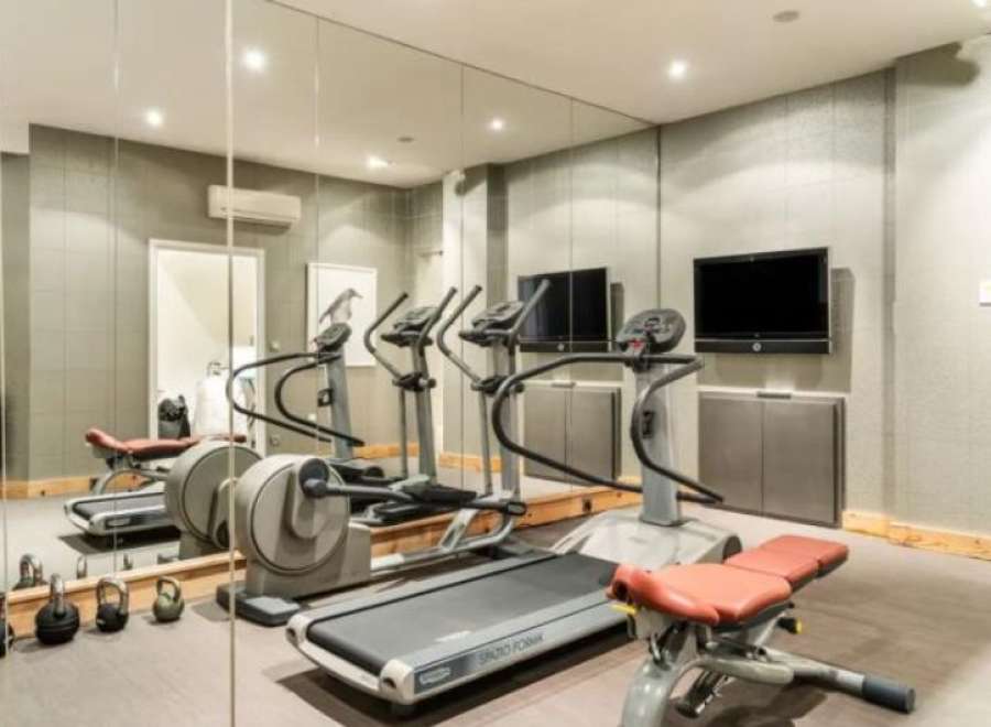 Luxury home gym with state-of-the-art equipment including treadmills and weight machines.