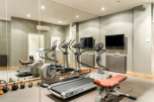 Luxury home gym with state-of-the-art equipment including treadmills and weight machines.