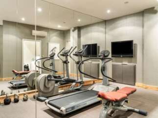 Luxury home gym with state-of-the-art equipment including treadmills and weight machines.