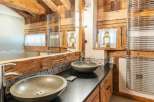Rustic-chic bathroom boasts double sinks and heated towel racks.