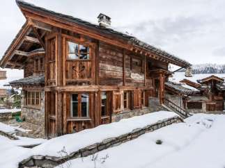 This stunning chalet boasts a unique blend of rustic charm and modern comfort, nestled in a breathtaking snowy mountain setting.