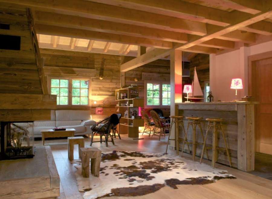 Rustic mountain chalet with exposed wood beams, a cozy fireplace, and a stylish bar area.