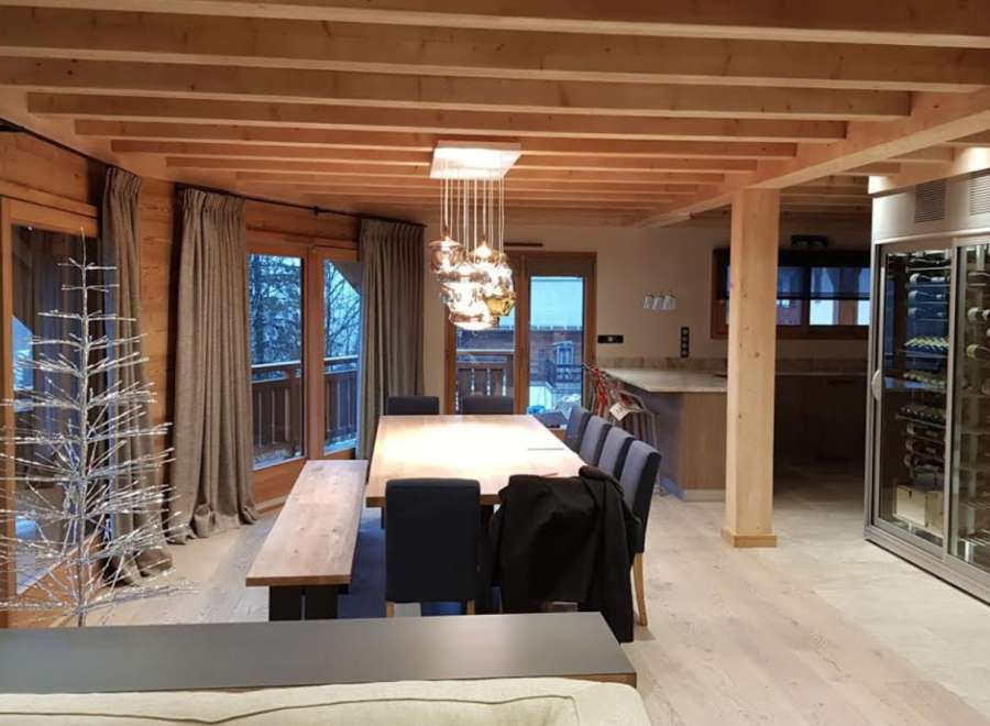This stunning chalet boasts a spacious open-plan living area with a large dining table perfect for entertaining.