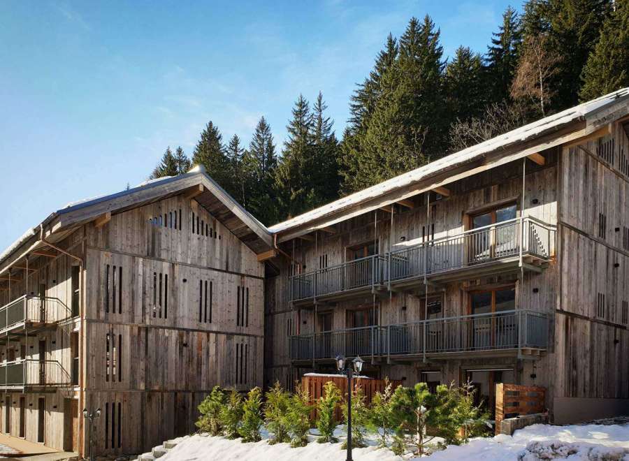 Discover a stunning wooden chalet nestled in a picturesque mountain setting.