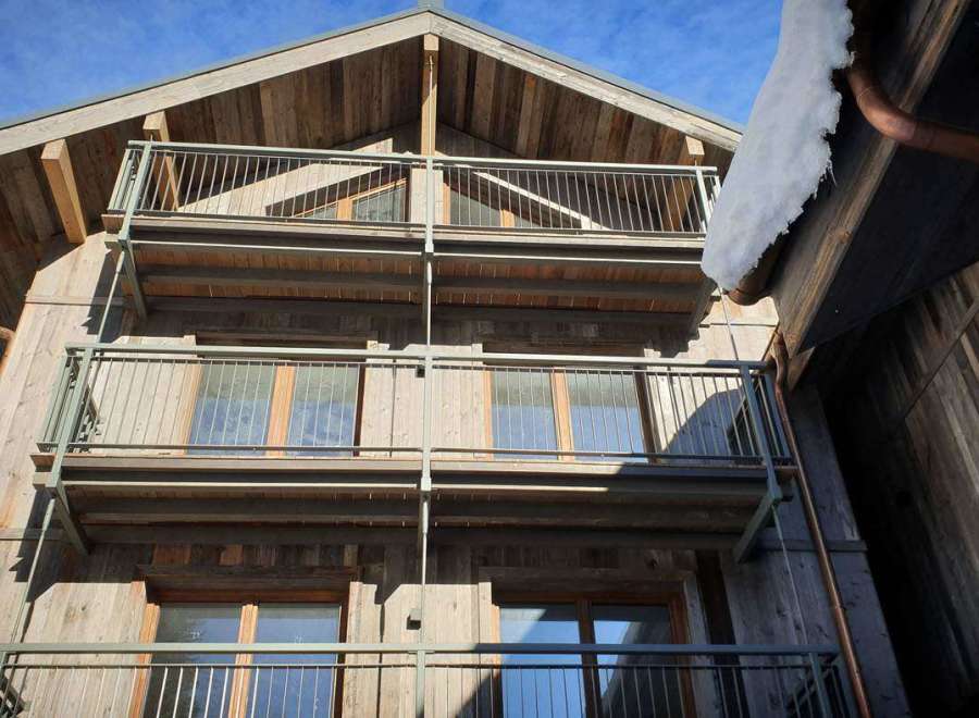 This stunning wooden chalet boasts multiple balconies, offering breathtaking views of the surrounding landscape.