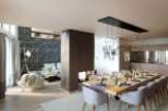 Stunning modern apartment boasting an open-plan living area with a feature fireplace and a sleek dining space.