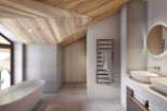 Luxurious bathroom boasts a freestanding tub, heated towel rack, and sleek double sinks.