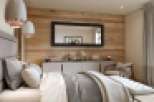 This stunning bedroom boasts a wood feature wall, creating a warm and inviting atmosphere.
