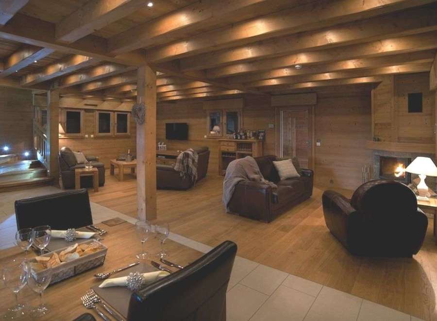 Luxurious chalet with exposed wooden beams, a cozy fireplace, and ample seating for relaxation.