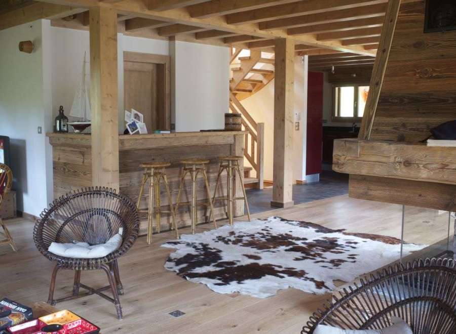 Rustic mountain chalet with exposed wooden beams, a cozy fireplace, and a stylish bar area.