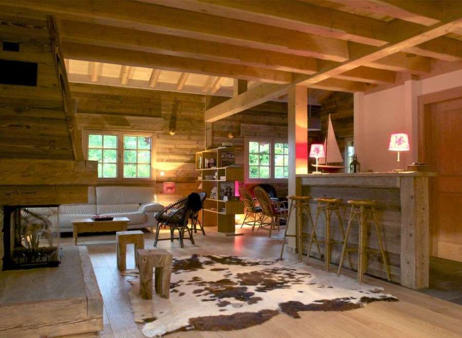 Rustic mountain chalet with exposed wood beams, a cozy fireplace, and a stylish bar area.
