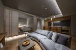 This modern apartment boasts a spacious open-plan living area with a curved sofa, perfect for relaxation.