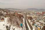 Explore the stunning winter landscape of Otaru, Japan, with this aerial view showcasing a modern highway cutting through a snow-covered town.
