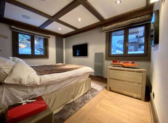 Luxury chalet bedroom with stunning mountain views, featuring a comfortable king-size bed and modern ensuite bathroom.
