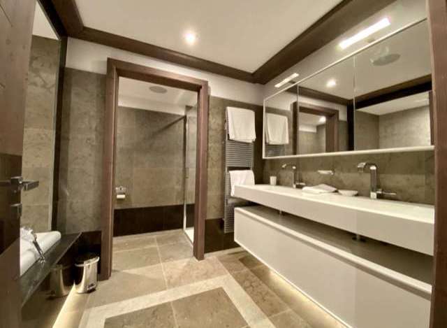 Luxurious bathroom with double vanity, modern fixtures, and spacious shower.