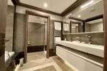 Luxurious bathroom with double vanity, modern fixtures, and spacious shower.