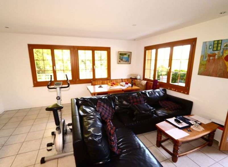 This bright and airy living space features large windows that flood the room with natural light.