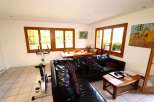 This bright and airy living space features large windows that flood the room with natural light.