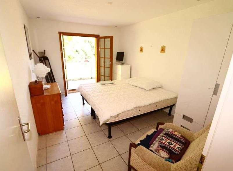 This cozy bedroom features a comfortable bed and a charming armchair, perfect for relaxation.