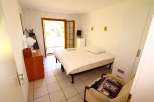 This cozy bedroom features a comfortable bed and a charming armchair, perfect for relaxation.