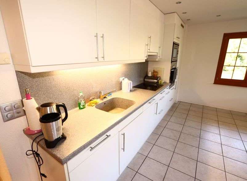 This bright and airy kitchen features modern white cabinetry and sleek countertops, perfect for preparing meals.