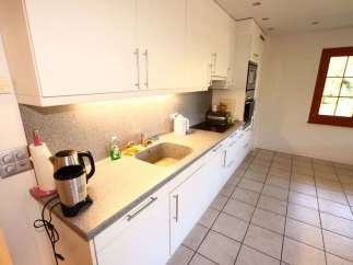 This bright and airy kitchen features modern white cabinetry and sleek countertops, perfect for preparing meals.