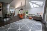 Stunning open-plan living area with a contemporary fireplace and large windows offering ample natural light.