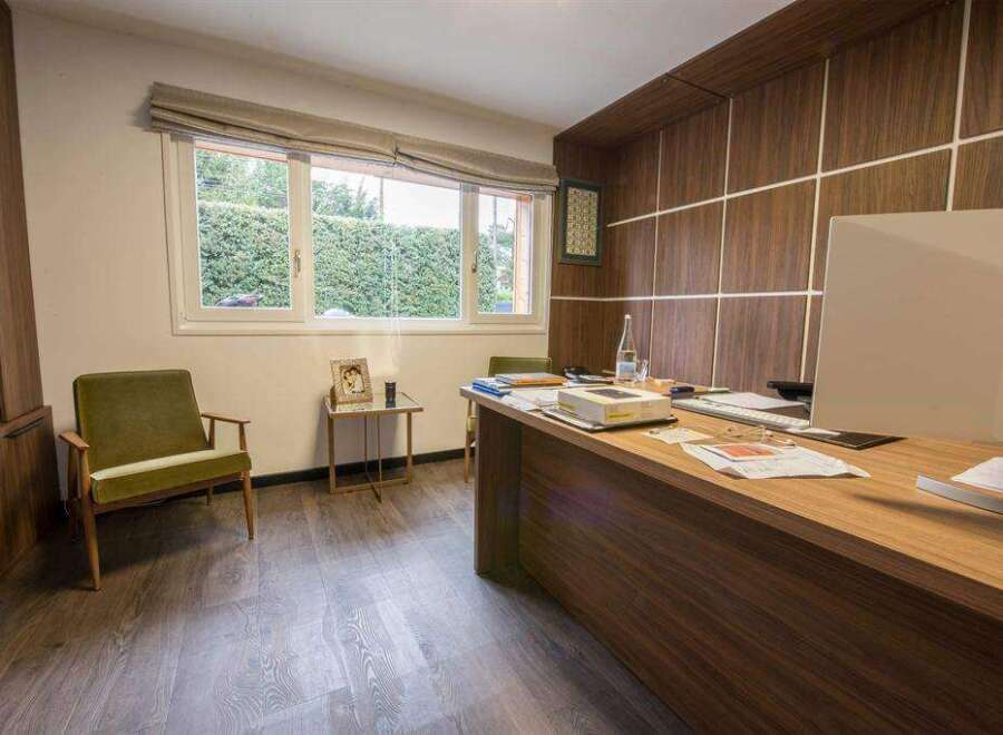 Modern office space with wood paneling and large window.