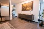 This stunning property boasts a spacious hallway with gleaming hardwood floors, a stylish sideboard, and elegant décor.