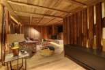 This stunning chalet boasts a cozy living area with exposed wooden beams and walls, creating a warm and inviting atmosphere.