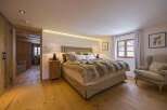 This cozy bedroom features a luxurious fur blanket and a comfortable armchair, perfect for relaxation.
