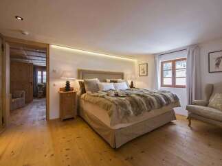 This cozy bedroom features a luxurious fur blanket and a comfortable armchair, perfect for relaxation.