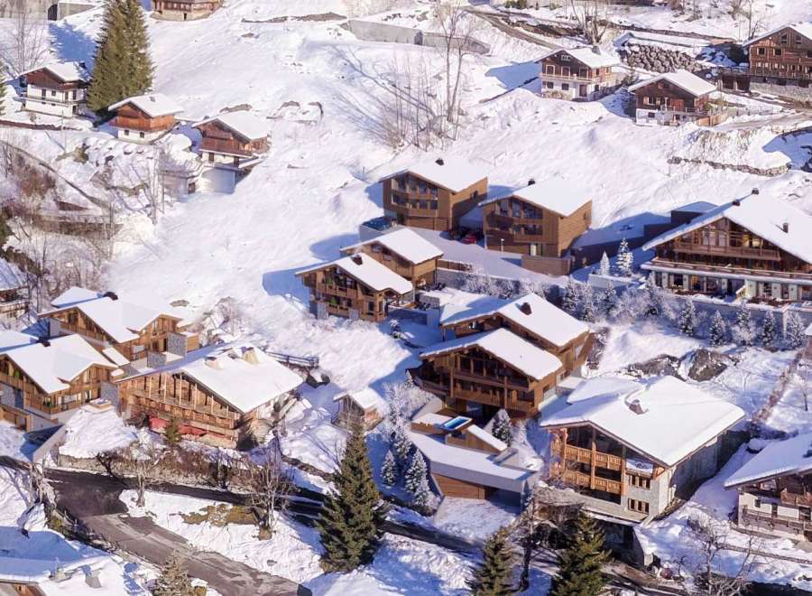 Discover the charm of these stunning chalets nestled in a snowy mountain landscape.