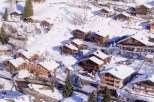 Discover the charm of these stunning chalets nestled in a snowy mountain landscape.