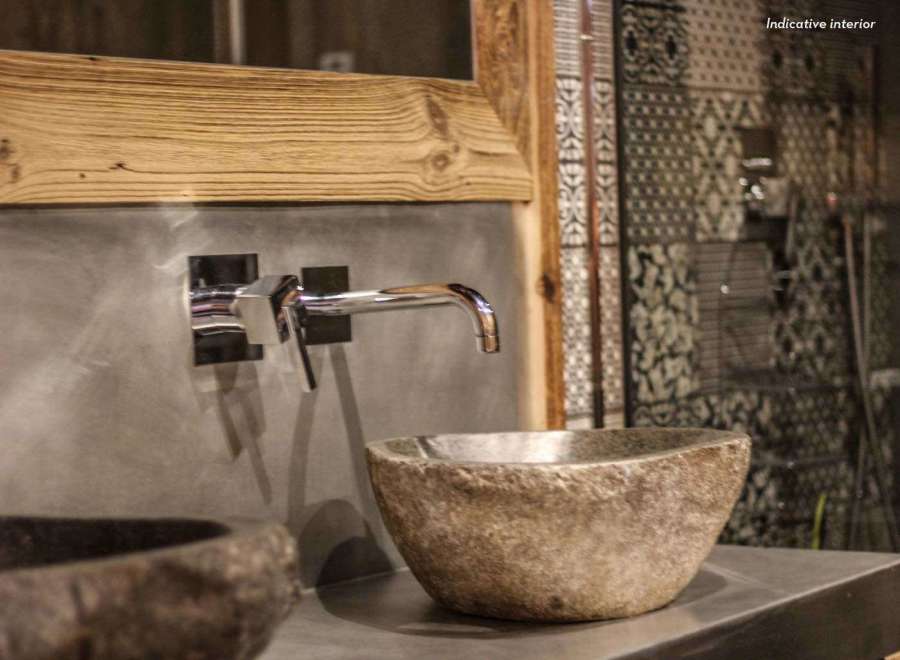 This stunning bathroom showcases a unique stone sink, adding a touch of natural elegance.