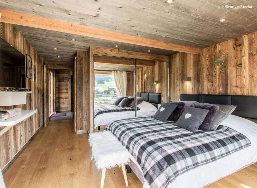 Experience rustic charm in this cozy bedroom, featuring warm wooden walls and a stylish plaid blanket.