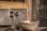 This stunning bathroom showcases a unique stone sink, adding a touch of natural elegance.