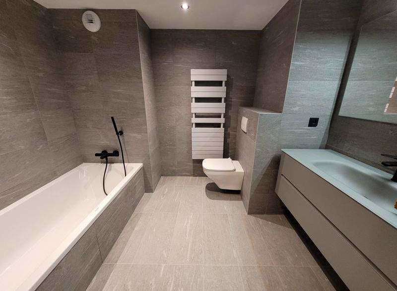 This modern bathroom features sleek gray tiling and a minimalist design.
