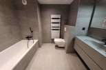 This modern bathroom features sleek gray tiling and a minimalist design.