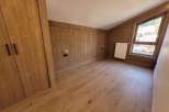 Discover the charm of this cozy room, featuring beautiful wooden paneling and flooring that exudes warmth.