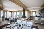 Experience luxury living in this stunning chalet, featuring a modern fireplace and a spacious dining area perfect for entertaining.