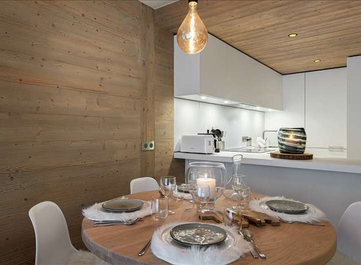 Experience the charm of this cozy dining area, featuring a rustic wooden table and inviting ambiance.
