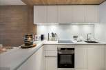 This modern kitchen boasts sleek white cabinetry and a minimalist design, perfect for a contemporary living space.