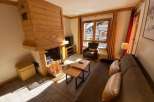 Cozy up in this charming living space, complete with a rustic wooden fireplace.